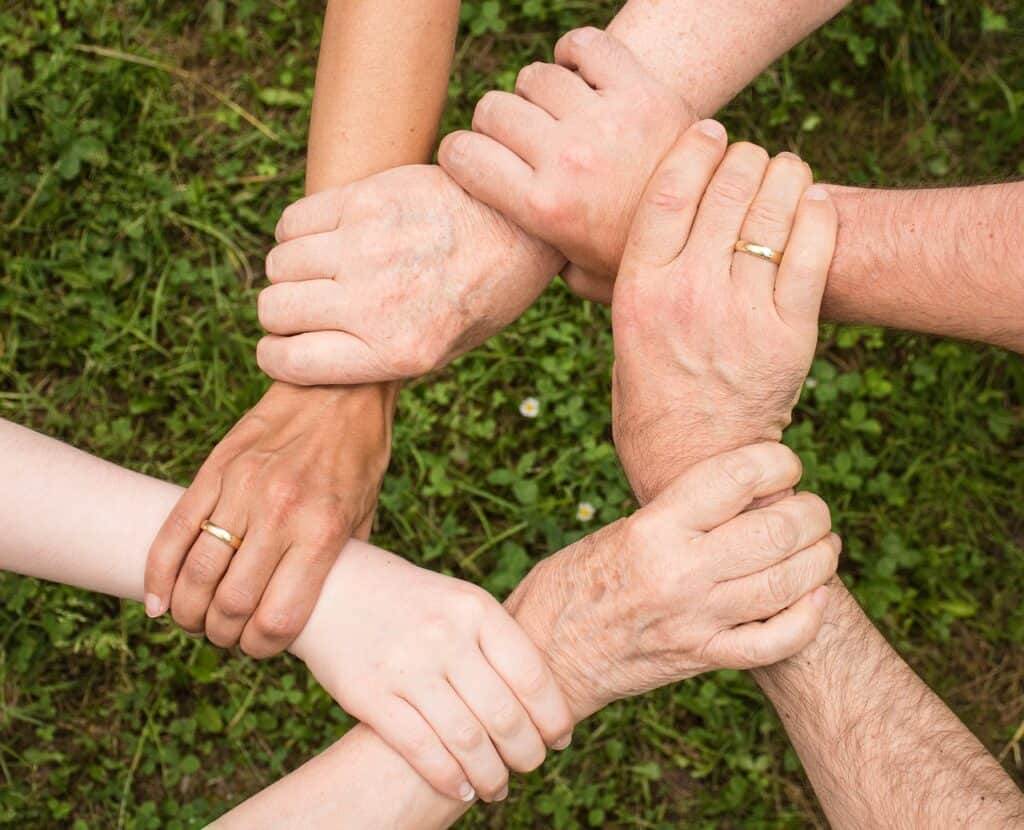 Hands joined together in a circle, symbolizing community and unity at Sierra Vista.